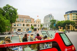 Tourists visit Hanoi by double-decker bus (Photo: VNA)