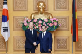 Prime Minister Pham Minh Chinh (R) hosts a reception for his Korean counterpart Han Duck Soo. (Photo: VNA)