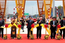 Prime Minister Pham Minh Chinh and other officials and former officials cut the ribbon to open Van Don – Mong Cai Expressway. (Photo: VietnamPlus)
