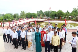 Vietnamese in Laos offer incense and flowers to President Ho Chi Minh. (Photo: VNA)