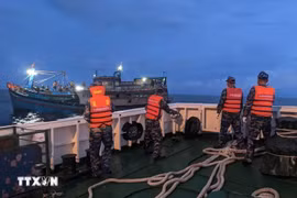 Vessel 468 of Navy Region 4 is able to access the fishing boat after two hours. (Photo: VNA)