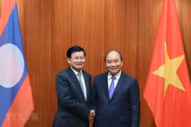 Prime Minister Nguyen Xuan Phuc meets with his Lao counterpart Thongloun Sisoulith during the Lao PM's visit to Vietnam on July 5. (Photo: VNA)