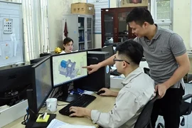 Engineers of Tomeco company in Hanoi's Ngoc Liep Industrial Cluster discuss industrial fan design (Photo: VNA)