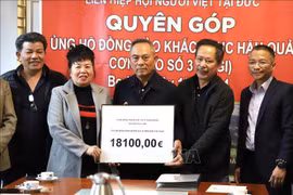 Nguyen Van Hien, president of the union of Vietnamese people associations in Germany, receives a donation of 18,100 EUR from Phan Thi Binh, a representative from Saxony-Anhalt state. (Photo: VNA)