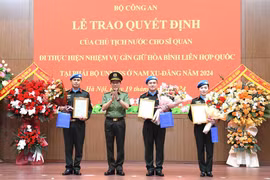 Authorised by the President, Minister of Public Security Sen. Lieut. Gen. Luong Tam Quang presents the decisions to the three officers (Photo: VNA)