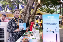 A Mongolian woman introduces her country and its people next to a banner announcing the plan for a direct flight from Ulaanbaatar to Ho Chi Minh City. (Photo: VNA)