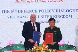 Sen. Lieut. Gen Hoang Xuan Chien and UK Minister of State for Defence Vernon Coaker sign minutes of the dialogue (Photo: VNA)