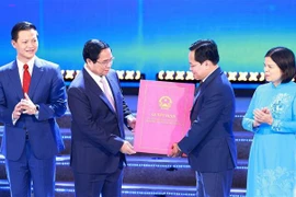 Prime Minister Pham Minh Chinh hands over the decision approving Bac Ninh's master plan for 2021-2023, with a vision to 2050. (Photo: VNA)