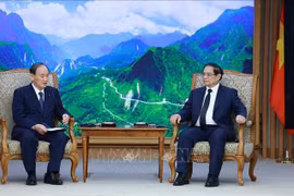 Prime Minister Pham Minh Chinh (R) and Special Envoy of Japanese Prime Minister Kishida Fumio and former Japanese PM Suga Yoshihide at their meeting in Hanoi on July 25 (Photo: VNA)