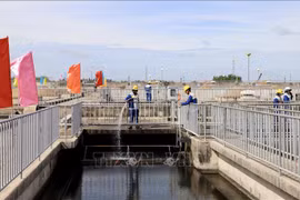 Workers spray water to clean the filtration tank and remove debris at the Binh Hung wastewater treatment plant in HCM City. (Photo: VNA)