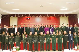 Participants pose for a group photo at the October 24 meeting marking the 75th anniversary of the traditional day of Vietnam’s volunteer soldiers and experts in Laos. (Photo: VNA)