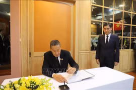 Thai Prime Minister Srettha Thavisin writes in the condolence book at the respect-paying ceremony at Vietnamese Embassies in Thailand on July 25. (Photo: VNA)