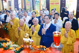 Prime Minister Pham Minh Chinh (second from the right, first row) and Vietnam Buddhist Sangha's dignitaries perform the traditional rituals of bathing the Buddha. (Photo: VNA)