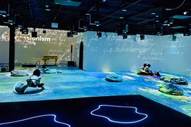 Visitors at the “Van Gogh & Monet Art Lighting Experience” exhibition (Photo: VNA)