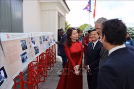 Deputy Minister of Foreign Affairs Nguyen Minh Hang (in red) and visitors at the exhibition. (Photo: VNA)
