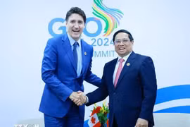 PM Pham Minh Chinh (R) shakes hands with his Canadian counterpart Justin Trudeau (Photo: VNA)