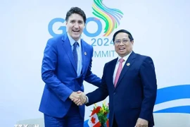 PM Pham Minh Chinh (R) shakes hands with his Canadian counterpart Justin Trudeau (Photo: VNA)