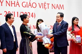 National Assembly Chairman Tran Thanh Man presents flowers to lawmakers who are teachers, and former teachers and education managers in Hanoi on November 20. (Photo: VNA)