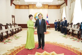 Lao Prime Minister Sonexay Siphandone (R) and VNA General Director Vu Viet Trang. (Photo: VNA)