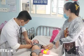 Treating a baby infected with measles (Photo: VNA)