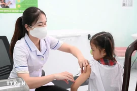 A nurse gives measles vaccine to a pupil. (Phôt: VNA)