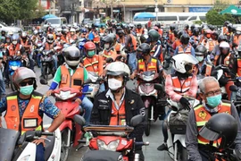 Motorcycle taxis parade in front of Bangkok City Hall in March last year to encourage riders to wear helmets. (Photo: bangkokpost)