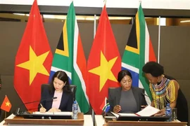 Vietnamese Deputy Foreign Minister Nguyen Minh Hang (L) and South African Deputy Minister of International Relations and Cooperation Anna Thandi Moraka sign the minutes of the 6th meeting of the Vietnam - South Africa Intergovernmental Partnership Forum in Pretoria on November 27. (Photo: VNA)