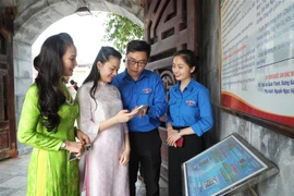 Youth Union members guide tourists to scan QR codes to learn about the Xuong Giang Victory historical site. (Photo: VNA)