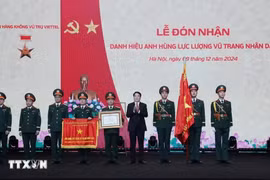 State President Luong Cuong (fourth from right) presents the title of Hero of the People's Armed Forces to the Viettel Aerospace Institute under the Viettel Military Industry and Telecoms Group (Viettel) at a ceremony on December 9 in Hanoi. (Photo: VNA)