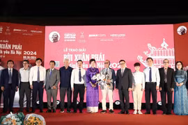 Participating delegates, representatives of the organisers of the Bui Xuan Phai - For the Love of Hanoi Awards congratulate Architect Hoang Dao Kinh on the stage. (Photo: VietnamPlus)