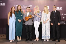 The BOND string quartet presents the concert organisers with a special gift – a violin signed by all four members. (Photo: VietnamPlus)