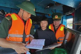 Border guards check documents and procedures before fishing boats leave the port. (Photo:VNA)