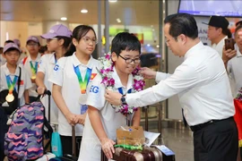 Director of the Hanoi Department of Education and Training Tran The Cuong welcomes the Vietnamese team returning from the 21st IMSO. (Photo: VNA)