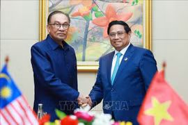 Prime Minister Pham Minh Chinh (R) and his Malaysian counterpart Anwar Ibrahim at their meeting in Vientiane on October 10. (Photo: VNA)