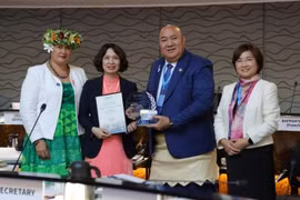 Deputy Minister of Health of Assoc. Prof. Nguyen Thi Lien Huong (2nd from left) receives a certificate and a plaque honouring Vietnam's elimination of trachoma. (Photo: nhandan.vn)