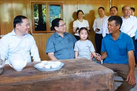 Prime Minister Pham Minh Chinh (second, left) visits a family benefited from the movement to build and repair houses for the needy in Hien Luong commune in Da Bac district of Hoa Binh province. (Photo: VNA)