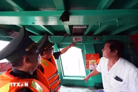 Border guards at Cat Lo border gate check the VMS device on the fishing boat of Nguyen Thanh Loi's family in ward 12, Vung Tau city, Ba Ria-Vung Tau province. (Photo: VNA)