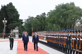 Lam and Xi pass an honour guard during a welcome ceremony for the former. (Photo: VNA)