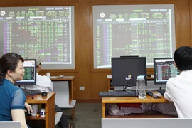 Investors watch the market and conduct transactions on a trading floor of a securities firm in Hanoi (Photo: VNA)