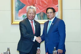 Prime Minister Pham Minh Chinh (right) receives President of the Asian Infrastructure Investment Bank (AIIB) Jin Liqun in Vientiane on October 10. (Photo: VNA)