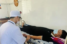 A medical worker takes care of people’s health at Vinh Hau A clinic, Hoa Binh district, Bac Lieu province. (Photo: VietnamPlus)