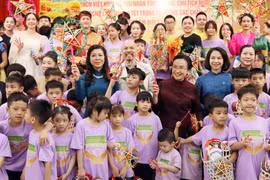 The spouse of Party General Secretary and State President of Vietnam To Lam, Ngo Phuong Ly (left, in blue dress), and the spouse of Party General Secretary and President of Laos Thongloun Sisoulith, Naly Sisoulith (right, in brown dress) join children of Birla Children's Village Hanoi in a celebration of the Mid-Autumn Festival on September 10. (Photo: VNA)