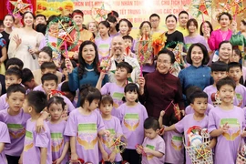 The spouse of Party General Secretary and State President of Vietnam To Lam, Ngo Phuong Ly (left, in blue dress), and the spouse of Party General Secretary and President of Laos Thongloun Sisoulith, Naly Sisoulith (right, in brown dress) join children of Birla Children's Village Hanoi in a celebration of the Mid-Autumn Festival on September 10. (Photo: VNA)