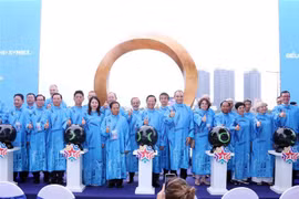 Leaders of HCM City and nearly 40 foreign localities pose for a photo in front of the international friendship symbol on September 24. (Photo: VNA)