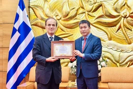 President of the Vietnam Union of Friendship Organisations Phan Anh Son (right) presents the honour to Greek Ambassador to Vietnam Georgios Stilianopoulos at the ceremony in Hanoi on October 15. (Photo: VNA) 