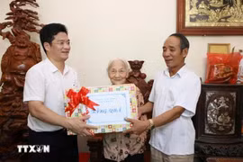 Standing Vice Chairman of the Nam Dinh provincial People's Committee Tran Anh Dung (first, left) presents a gift to Heroic Vietnamese Mother Tran Thi Chuc (centre), born in 1925, in My Thang commune of My Loc district. (Photo: VNA)