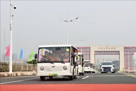 Electric vehicles carrying tourists cross Bac Luan II Bridge, part of the Mong Cai (Quang Ninh, Vietnam) - Dongxing (Guangxi, China) international border gates. (File photo: VNA)