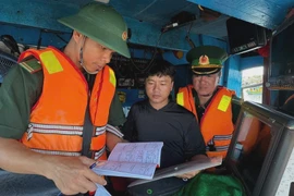 Quang Ngai border guards examine documentation of a fishing vessel. (Photo: VNA)