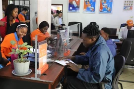 Mozambican customers register for telecommunication services at a branch of Movitel (a joint venture between Viettel from Vietnam and SPI from Mozambique) in Matola province. (Photo: VNA)