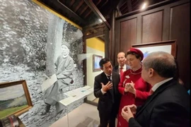 Amandine Dabat (in red), a fifth-generation descendant of King Ham Nghi, and officials of Thua Thien-Hue province visit an exhibition on the king. (Photo: VNA)